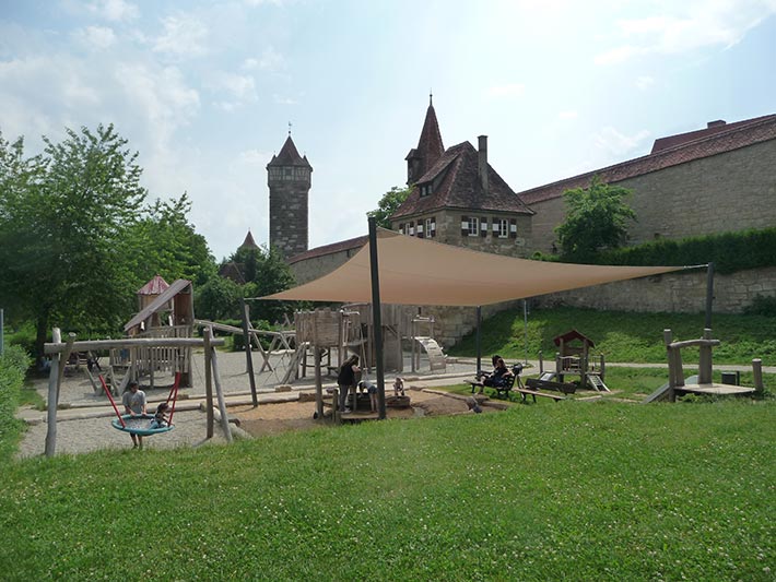 Rothenburg Spielplatz an der Stadtmauer mit Sonnensegel, Robinie und Eibe